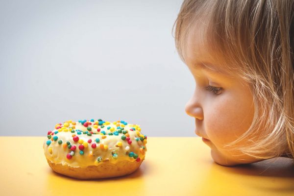 child not eating doughnut to tackle obesity and tooth decay
