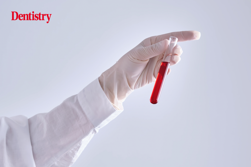 Current image: A medical professional holds up a test tube to check blood markers