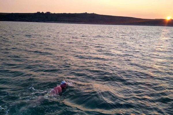 A dentist who braved a solo swim across the English Channel raised almost £7,000 for a dental charity