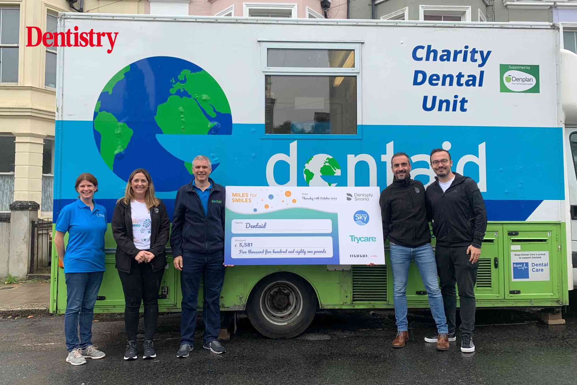 Dentsply team handing over their donation to Dentaid